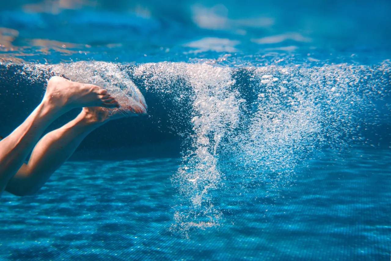Schwimmer im klaren, türkisfarbenen Beckenwasser – Symbolfoto für Badespaß in der Boddentherme
