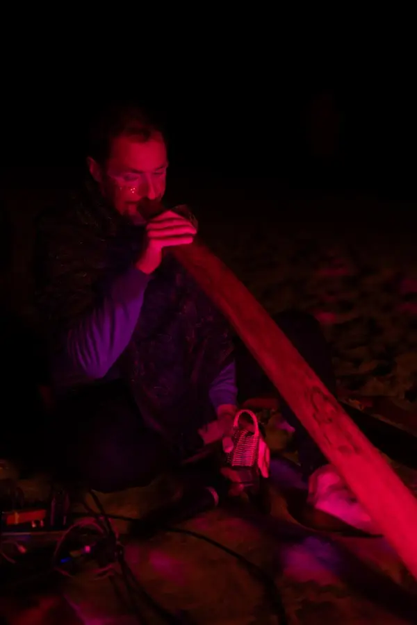 Musiker mit Didgeridoo im roten Licht
