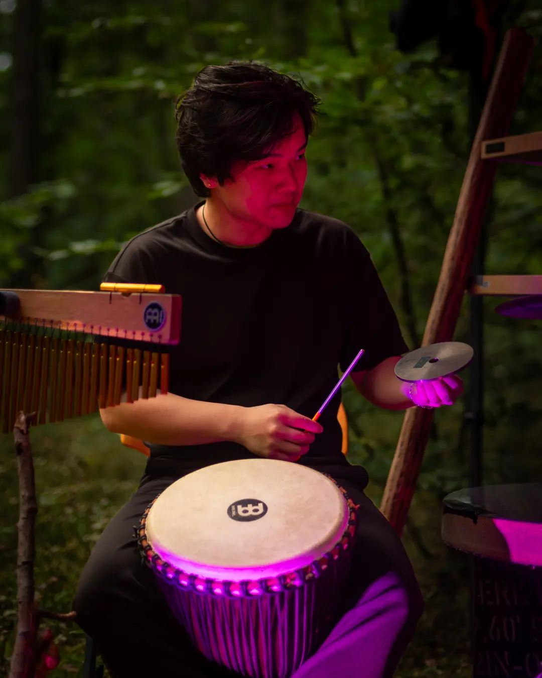 Trommler mit Djembe und Klangspiel im violetten Licht