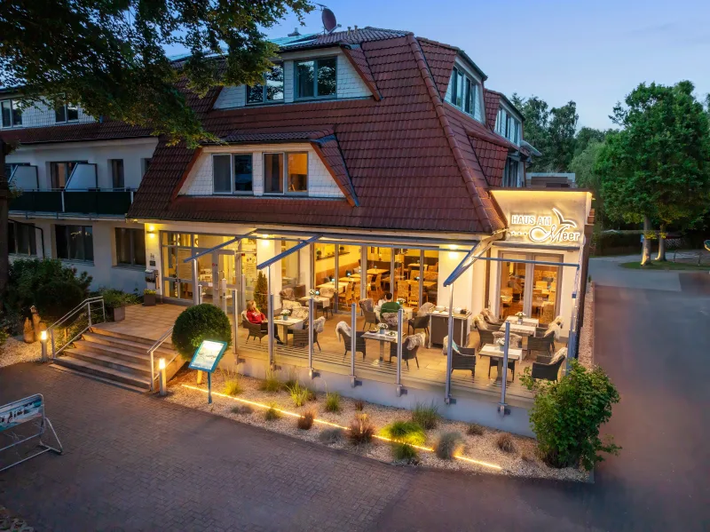 Restaurant »Buhne 36« im Hotel Haus am Meer in Graal-Müritz zur blauen Stunde – beleuchteter Wintergarten mit Terrasse